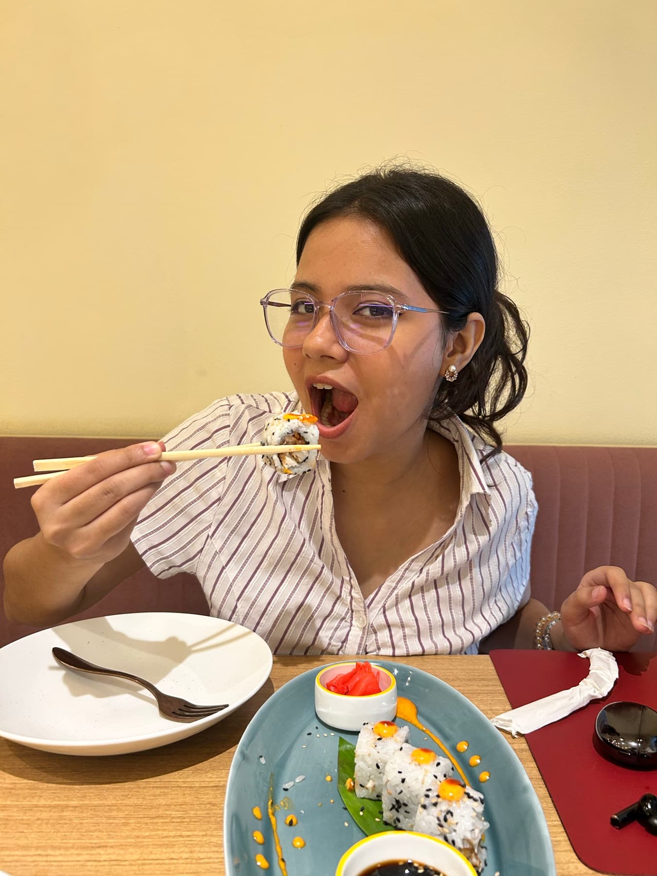 her first sushi. figured out chopsticks in ten minutes. annoyingly good at everything.